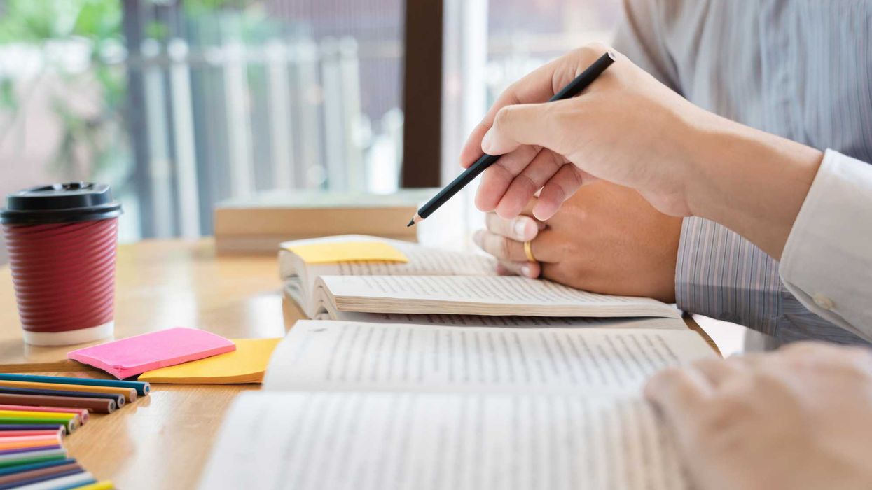 Two people with two books, open in front of them.
