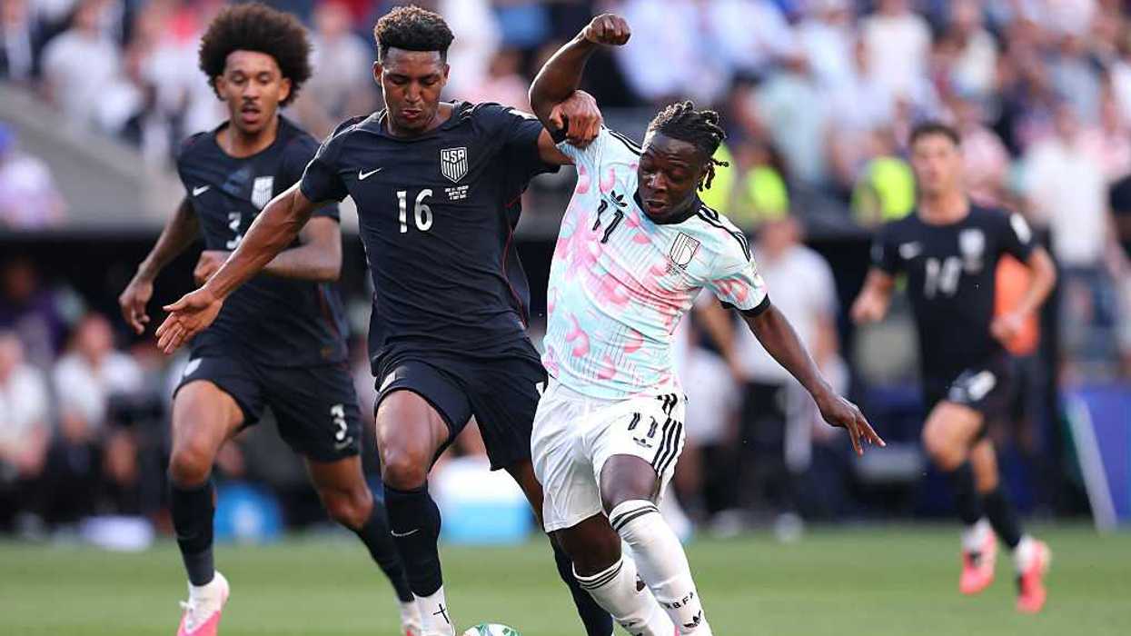 Two soccer, football, players colliding over the ball.
