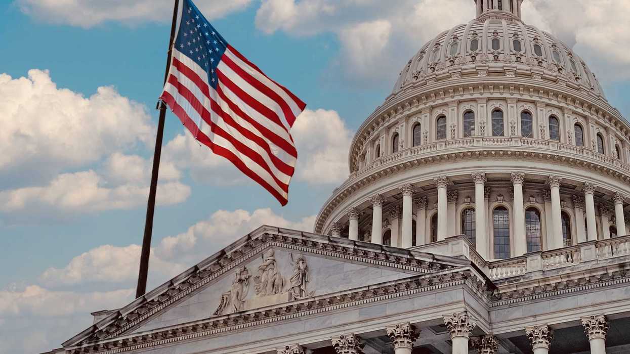 U.S. Capitol with a flag waving in front of it.