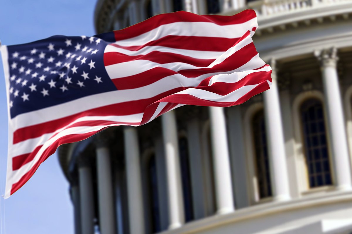 U.S. flag flapping in front of the Capitol Dome