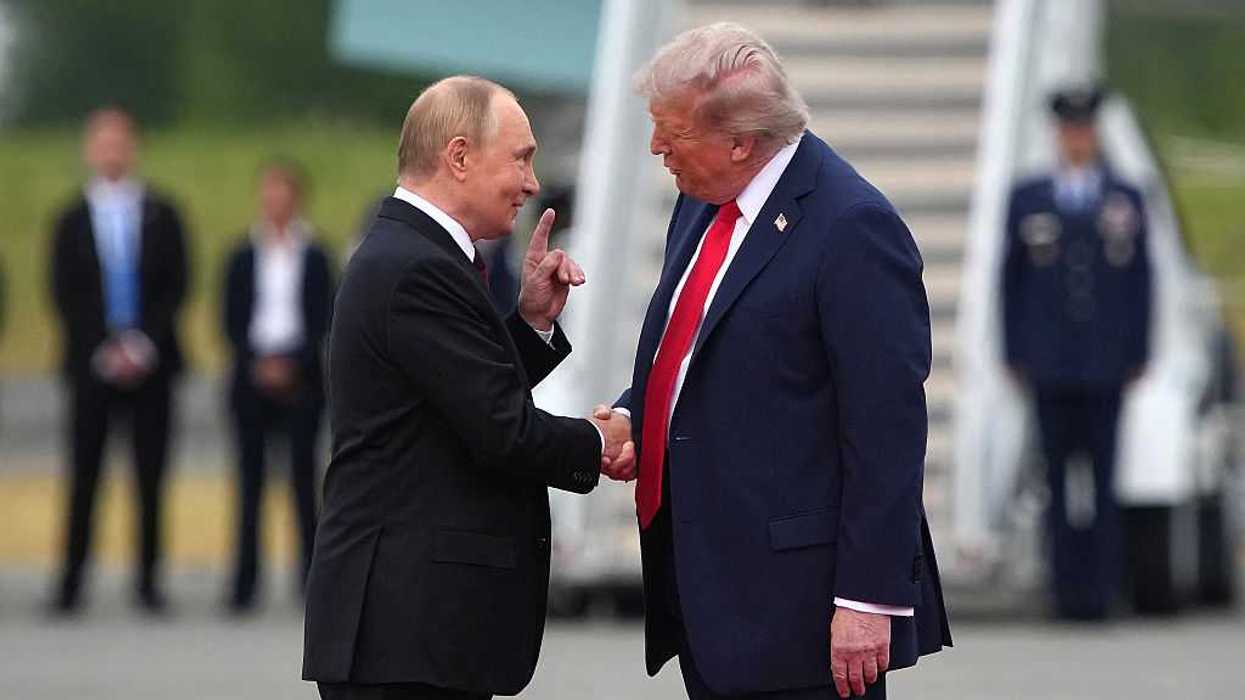 U.S. President Donald Trump greets Russian President Vladimir Putin in front of a landed airplane.