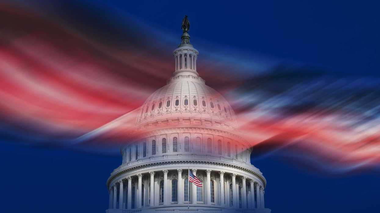 United States Capitol building and blurred American flag against blue sky