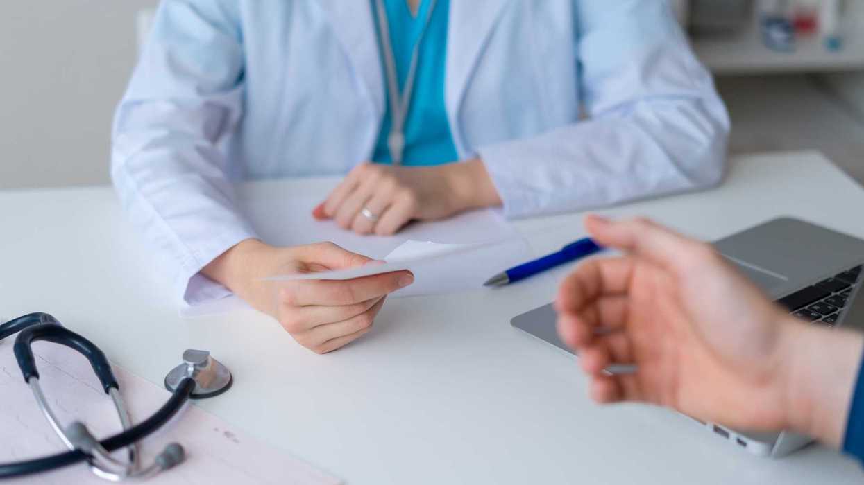 Unrecognizable doctor prescribing pharmacy to patient.