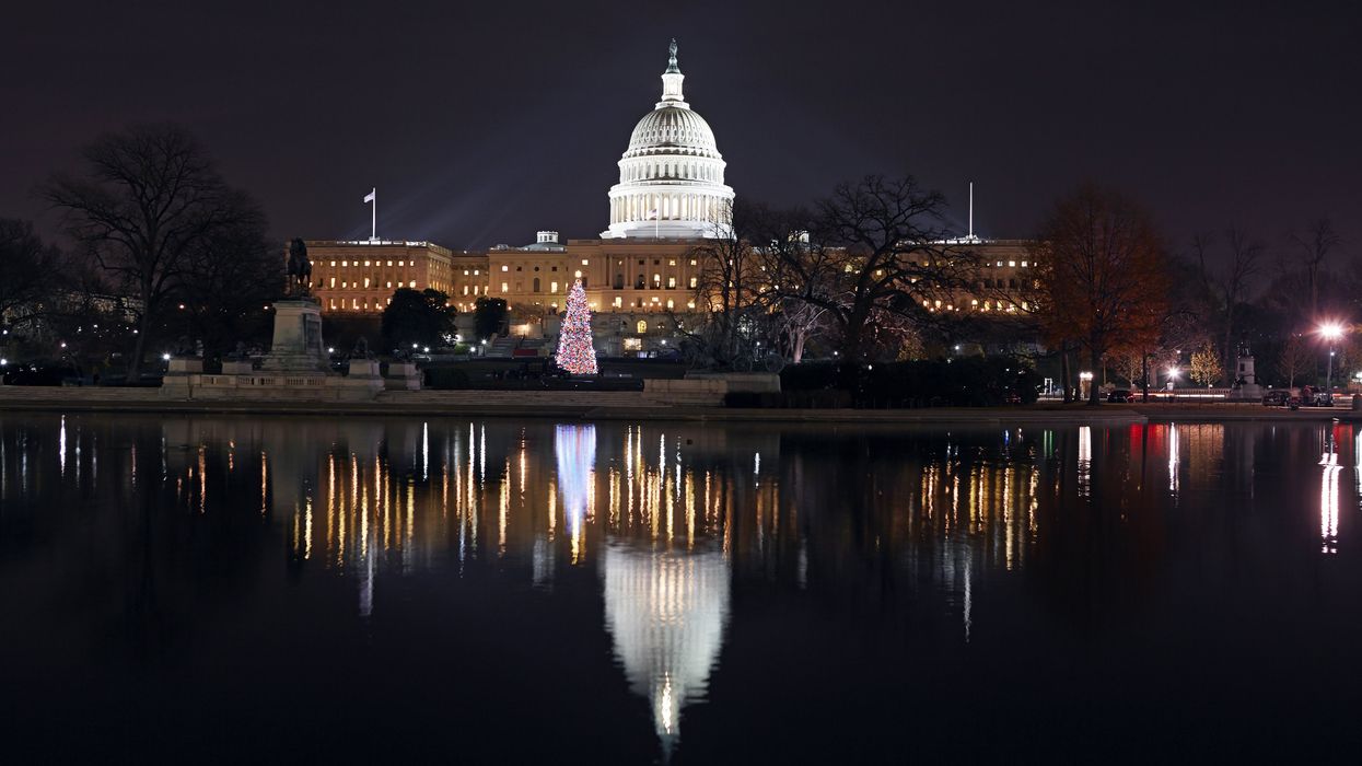 US Capitol building at night with Christmas tree and reflecting pool in foreground