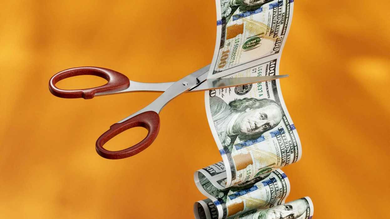 US money being cut by a scissor