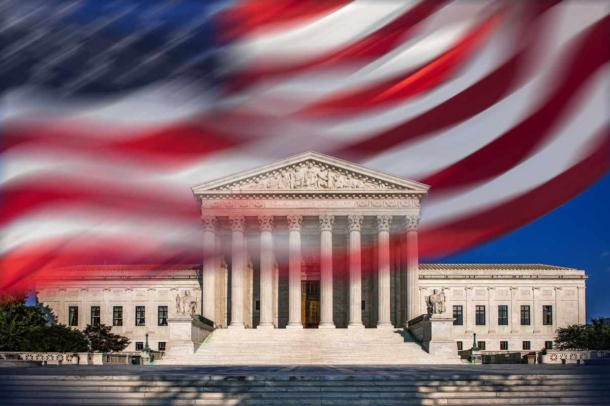 USA, Washington D.C., Supreme Court building and blurred American flag against blue sky.