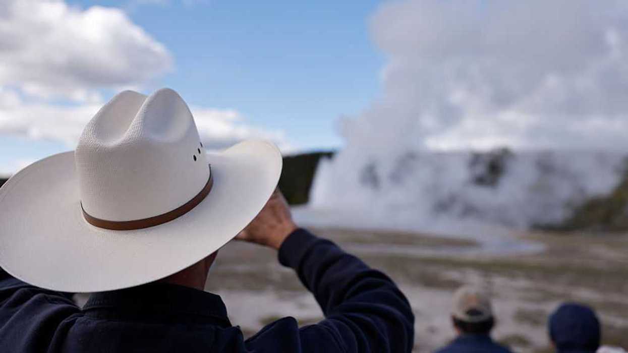 Visitors watch Old Faithful Geyser as an eruption winds down.