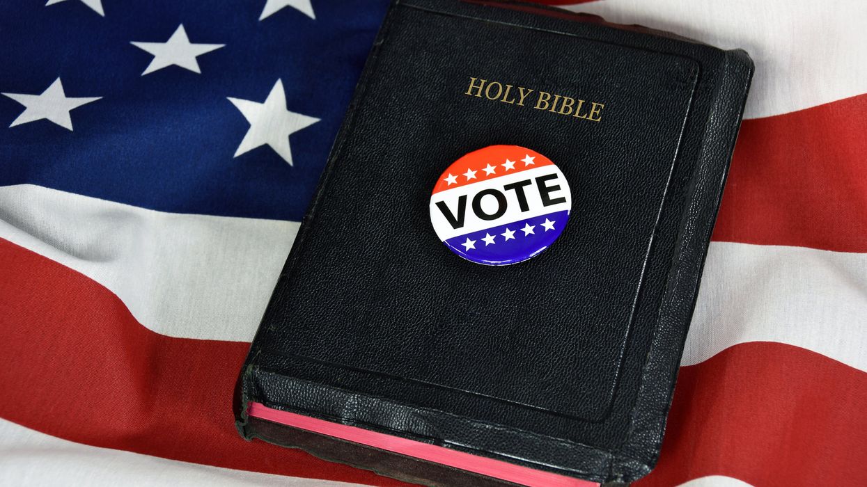 vote pin and Holy Bible on American flag