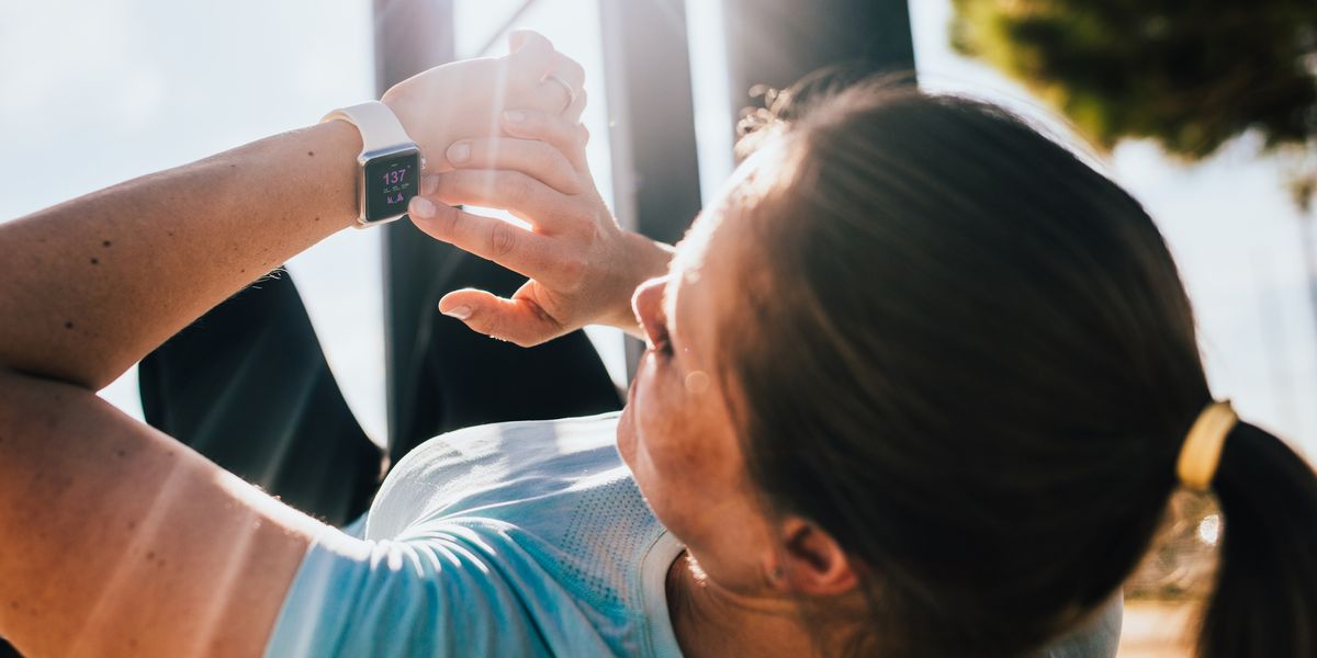 Woman looking at her smartwatch while exercising