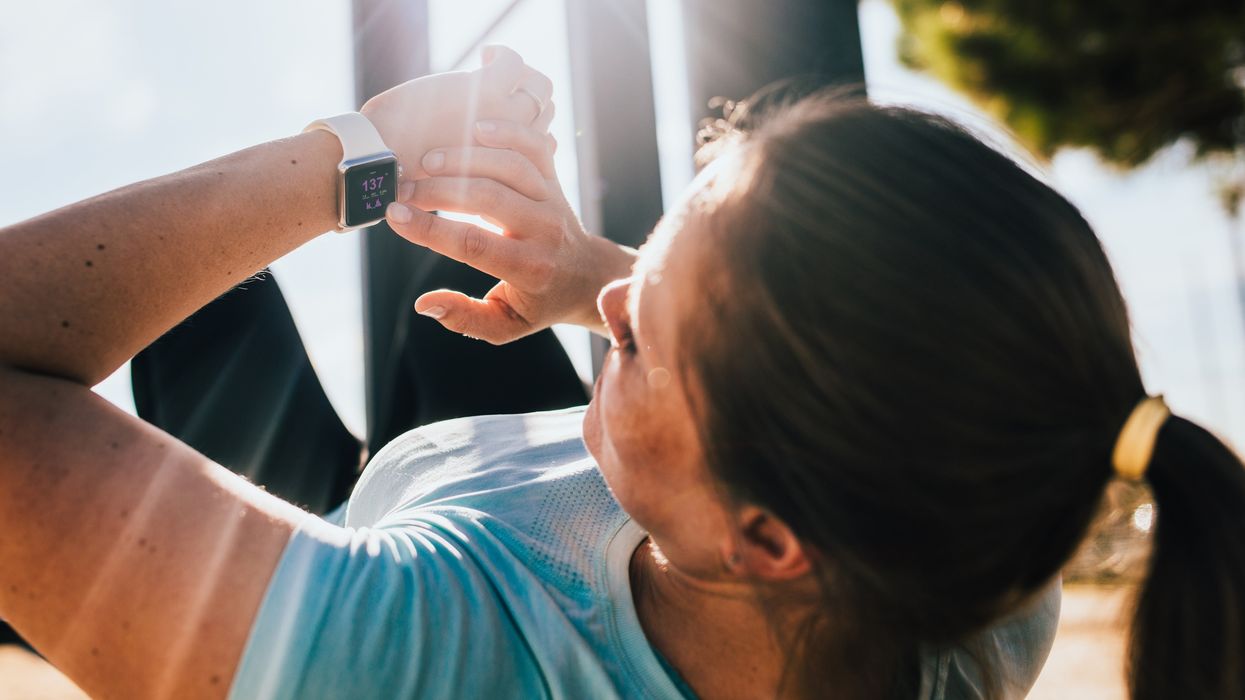 Woman looking at her smartwatch while exercising