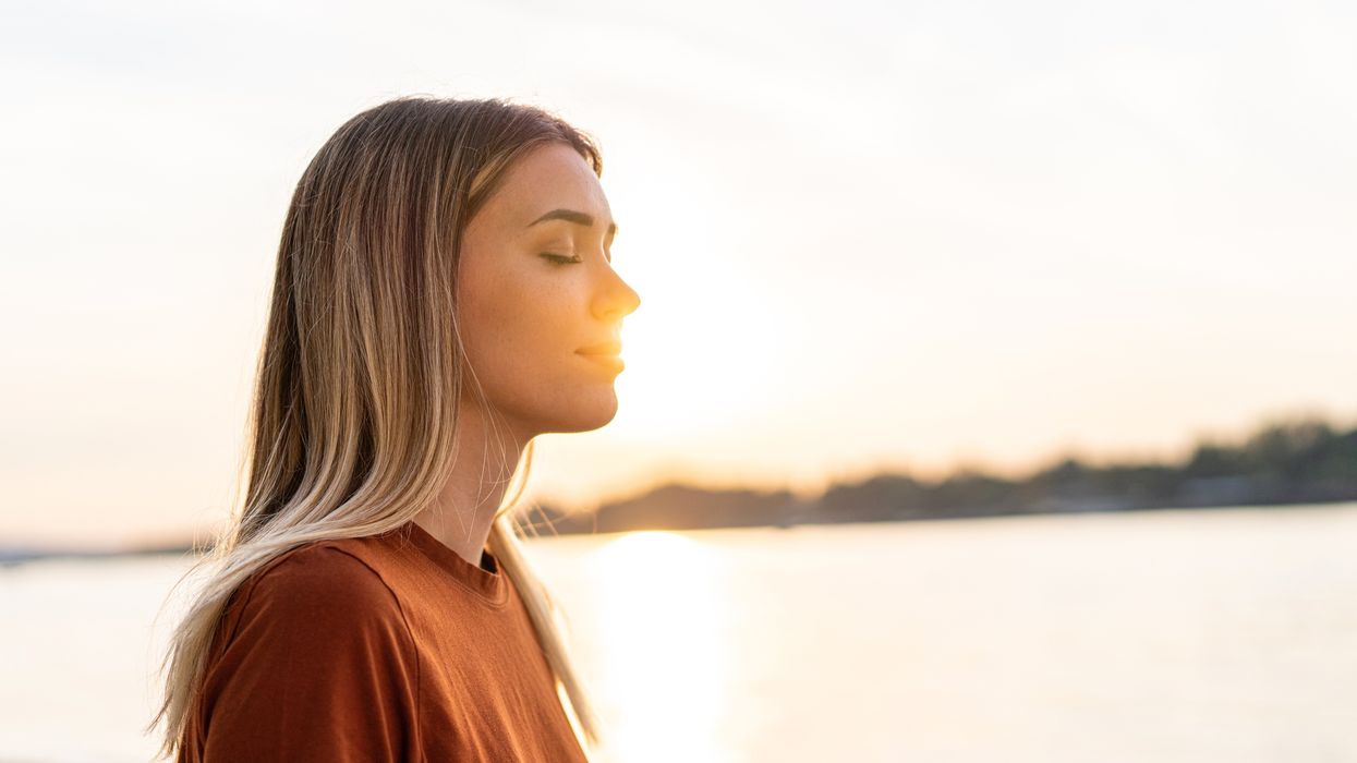 Woman mediating by a river