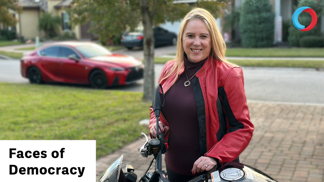 Woman standing next to a motorcycle