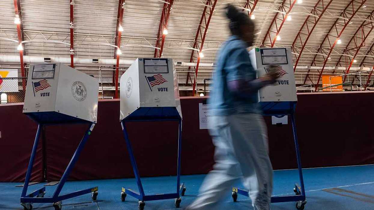 Women walks by voting booths.